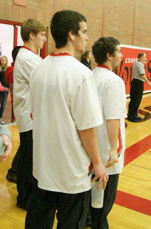 Left to right, Wolf hoopsters Caleb Valko, Ben Etzell and Drew Chan intently watch action in the girls game Friday.