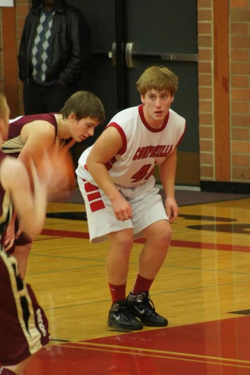 Caleb Valko (right) eyes the free-throw shooter as he prepares to launch in pursuit of a rebound.