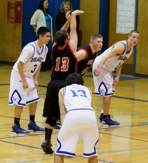 As Drew Chan lets a free throw fly, teammate Carson Risner prepares to launch in pursuit of a rebound.