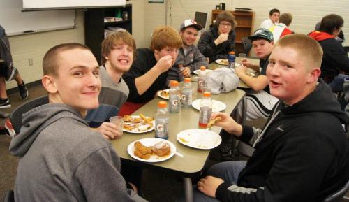 A table of players smiles for the camera. Valko, being a competitive eater, never slows down.