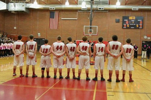 Trumbull (23) and teammates pause during the "Star Spangled Banner."