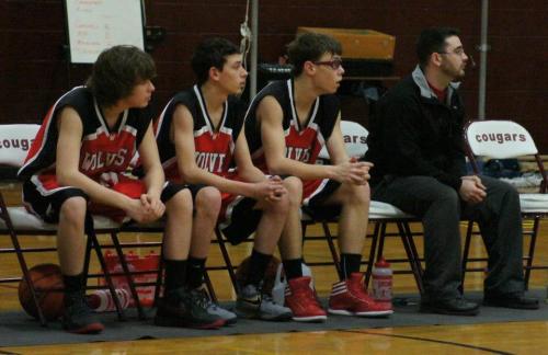 Wolf JV players (l to r) Isaac Vargas, Schuyler Montgomery and Jared Helmstadler join Coach V in watching the action. (Shelli Trumbull photo)