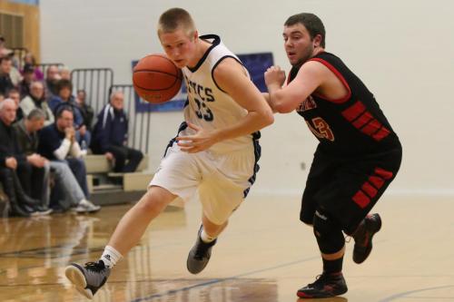 Drew Chan (right) tries to cut off the driving lane of a Lynden Christian player. (John Fisken photos)