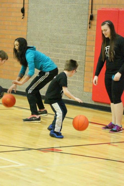 Makana Stone (left) and Hailey Hammer teach dribbling skills.