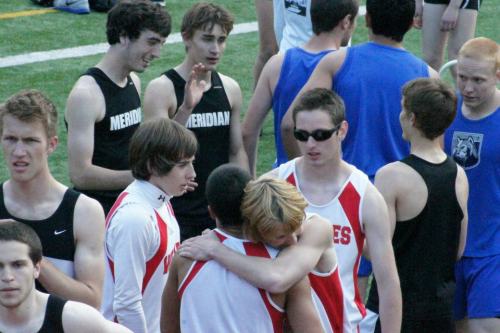 Hampton hugs 4 x 400 mate Mitch Pelroy after the Wolves tore up the track oval. Watching are Larry Hurlburt (left) and Sam Landau.