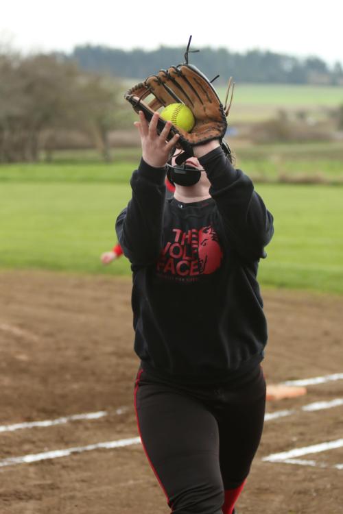 Battling gusty winds, Hailey Hammer hauls in a pop-up in foul territory.
