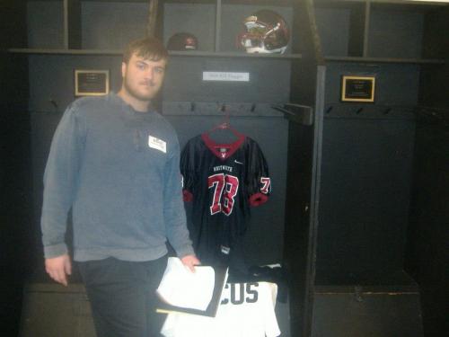 Anthony Maggio poses next to what could be his locker during a trip to Whitworth University.