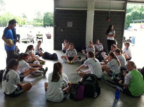 The Whidbey Islanders GU18 soccer squad preps for tourney play, while goalie Kenzie Perry (in green) photo-bombs her teammates. (Kerry Rosenkranz photo)