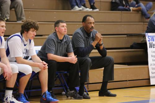 Henry Pope (far right), on the bench guiding his Falcons during basketball season. (John Fisken photos)