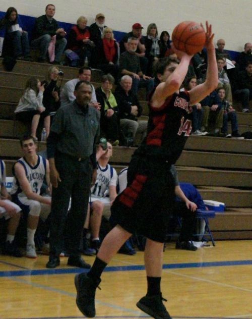 South Whidbey High School boys' basketball coach Henry Pope watches as Wolf Wiley Hesselgrave shoots in a game this season. (Shelli Trumbull photo)