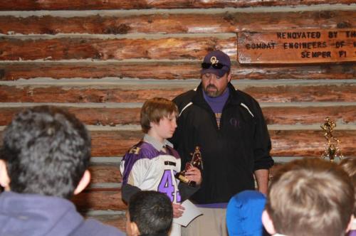 Jacob Martin (left) receives a trophy for his play on the football field.