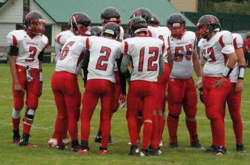 The Wolves, led by quarterback Gunnar Langvold (6), huddle up.
