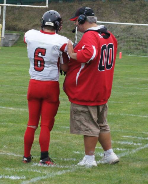 Wolf quarterback Gunnar Langvold discusses strategy with coach Tony Maggio.