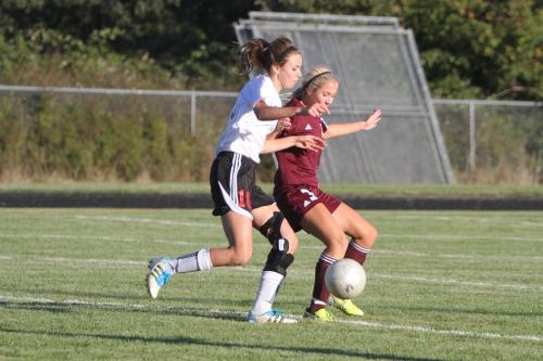 Julia Myers (left), back on the field after an injury cost her last season, fights for a loose ball.