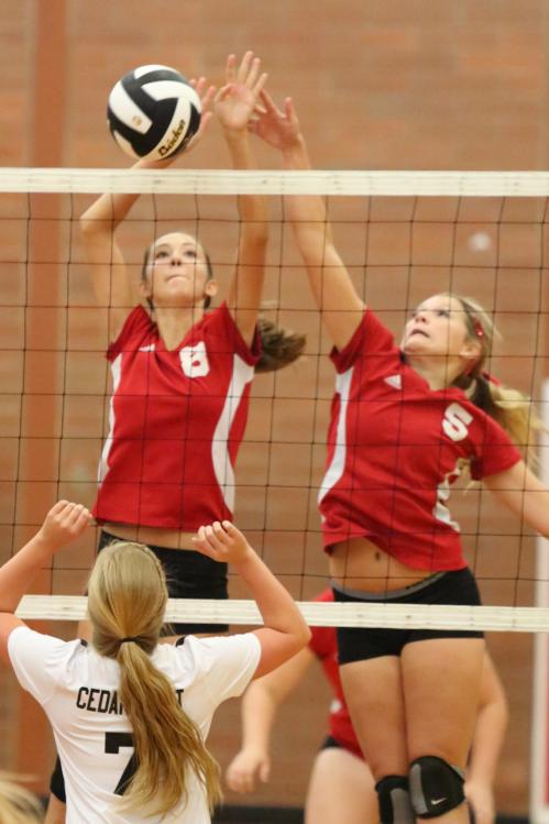 Allie Hanigan (left) and Breeanna Messner team up to stuff a shot at the net.
