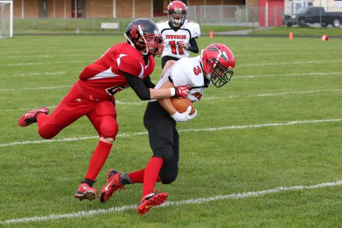 Cole Payne catches a rampaging Redskin runner. (John Fisken photos)