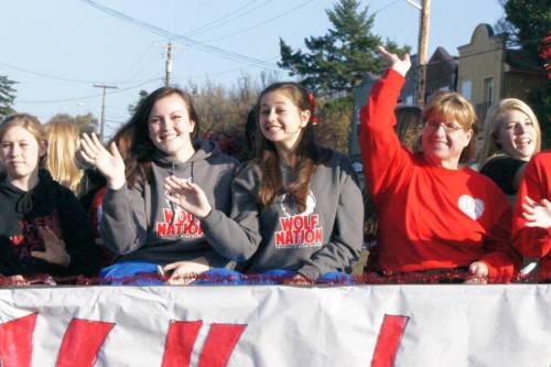 Wolf volleyball players and coaches perfect their pageant waves.