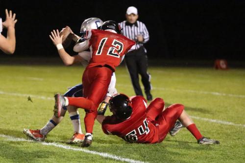 Josh Bayne (12) and Matt Shank (64) team up to bring down the Chimacum QB. (John Fisken photos)