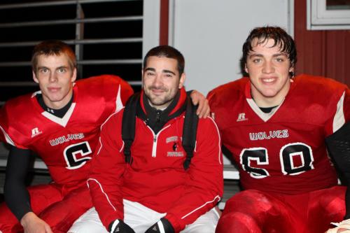 Assistant coach (and former Wolf player) Dustin Van Velkinburgh has a moment with seniors Gunnar Langvold (left) and Nick Streubel.