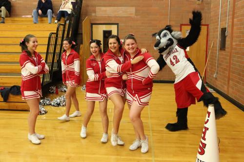 Wolf cheerleaders joke around with the mystery man in the new, improved CHS mascot outfit.