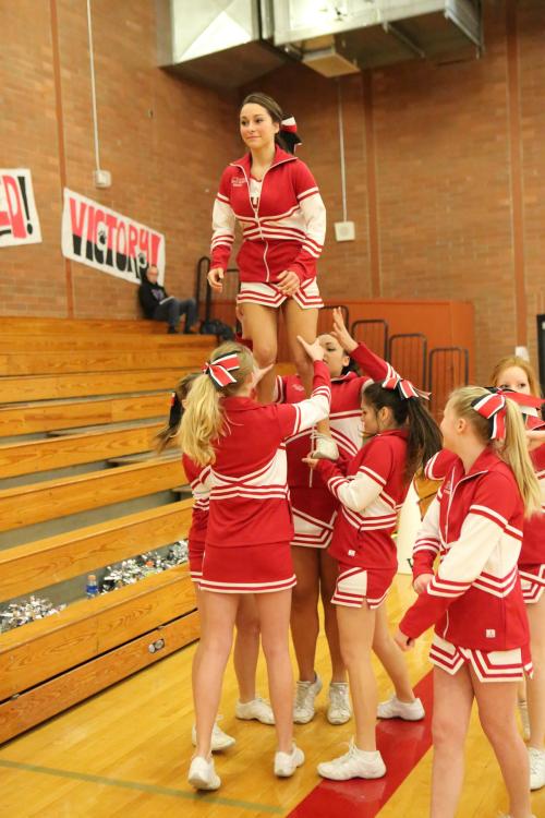 Senior cheer co-captain Emilee Crichton gets up above the net.