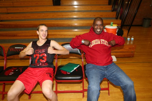 Wolf boys' hoops coach Anthony Smith (right) and junior guard Joel Walstad hang out pre-game.