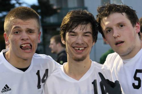 Cameron Boyd (center) gets props from Jared Dickson (left) and Brett Arnold after sacrificing his tooth in a win over South Whidbey. (Sylvia Arnold photo)