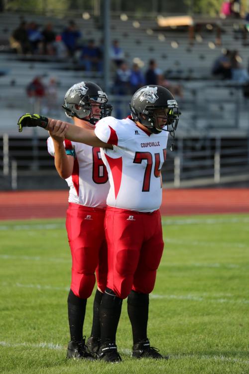 James Vidoni (back) help fellow lineman Brenden Gilbert stretch in pre-game warmups.