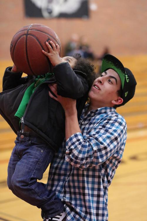 Brandon Jansen gives a young fan a little help during the halftime shooting contest. (John Fisken photos)