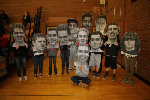 Fans pose with giant Fat Heads of the Wolf varsity players made by Shelli Trumbull.
