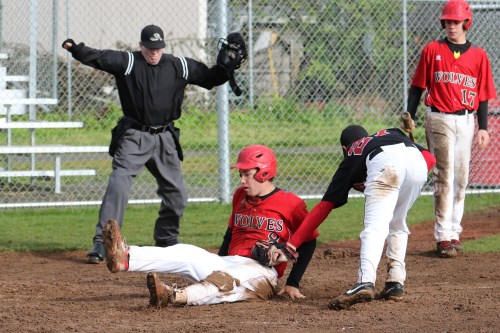 A muddy (but safe) Aaron Trumbull slides across home.