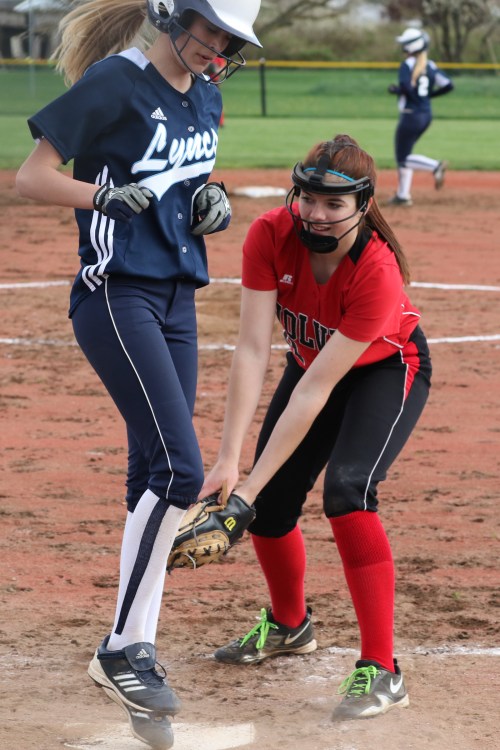 Katrina McGranahan slaps a tag on a surprised Lynden Christian runner. (John Fisken photos)