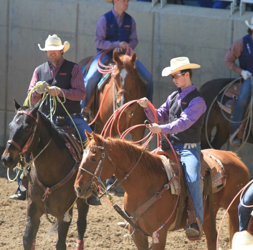 Brendan Coleman (right) gets ready for his roping competition.