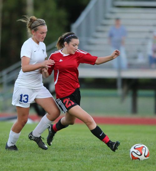 Kalia Littlejohn (right) bulldozes her way to own of her 10 goals during the high school season. (John Fisken photo)