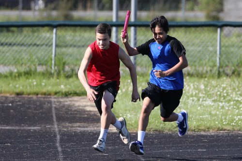 Sean Toomey-Stout (in red) and Nick Wielandt work on their relay hand-offs. (Fisken photo)